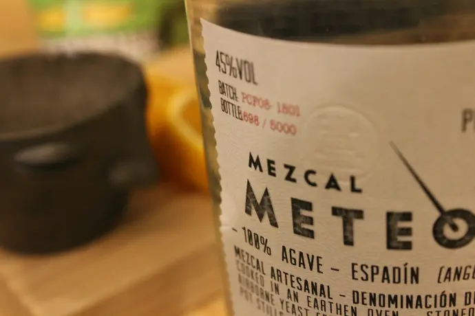 botella con etiqueta blanca sobre mesa de madera marrón